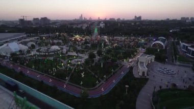 Bir dron lunaparkın üzerinde atlı karınca ve dönme dolap ile uçuyor. Hava görünümü.