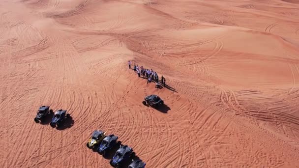 無人機が砂漠の砂丘を駆け抜けるバギーに乗って飛ぶ エアリアルビュー — ストック動画