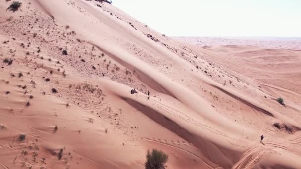 无声无息地看到人们骑在沙漠沙丘上的木板上 空中视图 — 图库视频影像
