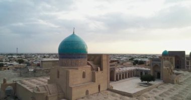 Bir İHA, Poi-Kalon mimari kompleksinin üzerinde uçuyor. Özbekistan 'ın eski Buhara kentindeki bir evin arka planında. Bulutlu bir gün. Hava Görünümü.