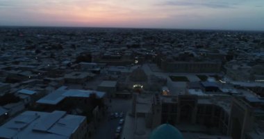 Özbekistan 'ın Buhara kentindeki eski evler arasında Poi-Kalon mimari kompleksinin üzerinde bir dron uçuyor. Erkenden bulutlu bir sabah. Hava Görünümü.