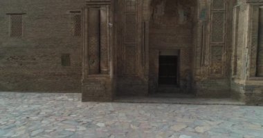 İnsansız hava aracı Özbekistan 'ın eski Buhara kentindeki Magok-i-Attari cami kompleksinin antik kapılarına yakın uçuyor. Bulutlu bir gün. Hava Görünümü.