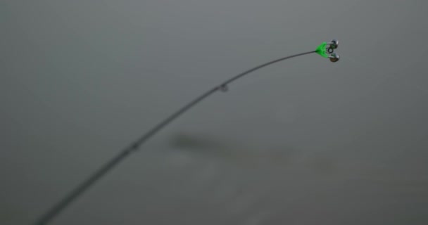 带铃铛的钓竿 漂浮在流动的水中 重点从钓竿转移到水面 然后再返回 慢动作 — 图库视频影像