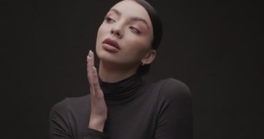 Stüdyoda siyah arka planda genç bir kadının portresi çekiliyor. Yavaş Hareket.