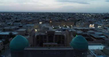 Şafakta eski şehrin ve ünlü anıt kompleksi iKalyan Poi Kalon Kompleksi ve Poi Kalon Minaret n Bukhara 'nın üzerinde bir dron uçar. Hava manzarası, Özbekistan.