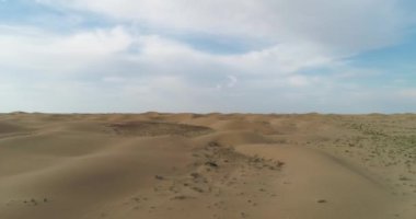 Bir İHA bulutlu bir günde çölün yüzeyinden havalanıyor.