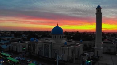 Bir İHA şehrin camisinin etrafında Sunrise 'ın arka planına doğru uçuyor. Bulutlu bir sabah. Hava Görünümü.