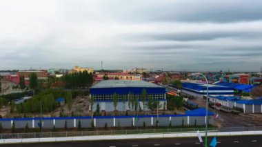 İnsansız hava aracı hareket halindeki arabalarla şehrin yollarında ve otoyollarında uçuyor. Bulutlu bir yaz günü. Hava Görünümü.