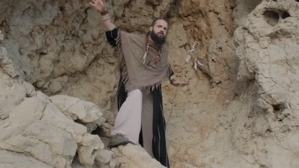 Young Bearded Man Staff His Hands Clothes Shaman Prays Rock — Stock Video
