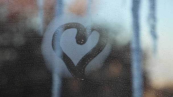 在冰柱和冬城的背景下 雾蒙蒙的窗户上有心形图案 — 图库视频影像