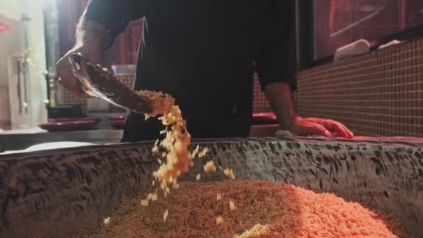 Der Koch Wirft Reis Mit Einem Schlitzlöffel Einen Großen Kessel — Stockvideo