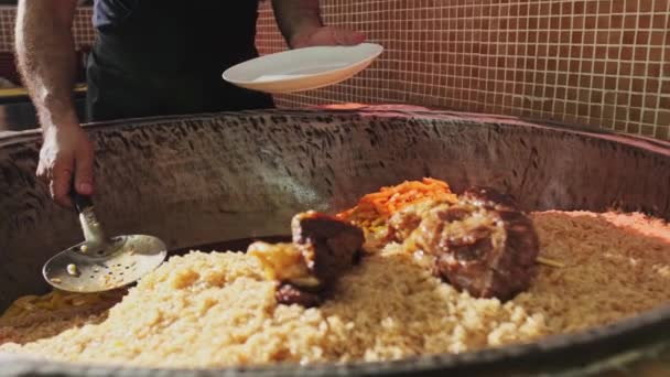 Šéfkuchař Dává Rýži Rozříznutou Lžičkou Talířů Velkého Kotle Pilaf Pomalý — Stock video