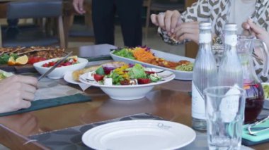 İnsanlar restoranda bir masaya oturur ve yemek yerler. Kapat, Yavaş Hareket.