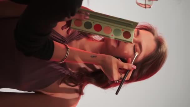 Profesjonalny Makijażysta Maluje Oczy Młodej Ładnej Modelki Długimi Włosami Oświetlenie — Wideo stockowe