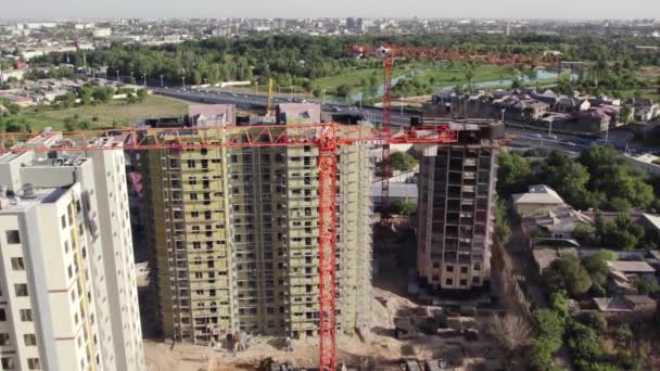 Drone Przelatuje Nad Żurawiem Budowlanym Wśród Budynków Mieszkalnych Trakcie Budowy — Wideo stockowe