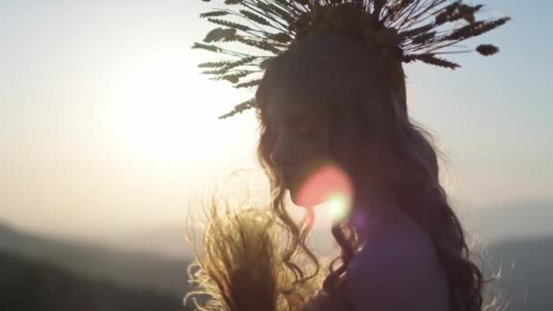 秋の花の衣装を着た若い女性のクローズアップと山の日没の背景に葉 フォーカスは前景から背景に移ります スローモーション — ストック動画