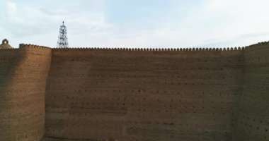 Özbekistan 'ın Buhara kentindeki eski evlerle çevrili antik Ark kalesinin tuğla duvarları. Bulutlu bir sabah. Drone, Hava Görüntüsü.