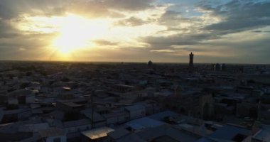 Bir dron, günbatımı gökyüzünün arka planında antik bir Lyab-i Hauz kompleksinin üzerinden uçuyor. Eski Buhara, Özbekistan civarında. Hava Görünümü.