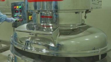 Koruyucu giysiler içindeki kimyager laboratuvarda büyük bir gezegen mikseri ile çalışıyor. Yavaş Hareket, Kapat.