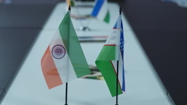 办公室桌上挂着乌兹别克斯坦和印度国旗的标语 慢动作 — 图库视频影像