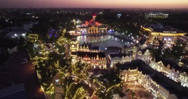 İnsansız hava aracı, bir eğlence parkının şatosunun üzerinde şarkı söyleyen bir çeşmeyle uçuyor. Hava Görünümü, Yavaş Hareket.