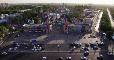 Bir İHA turist ve misafirlerle dolu bir lunaparkta uçuyor. Hava Görünümü.