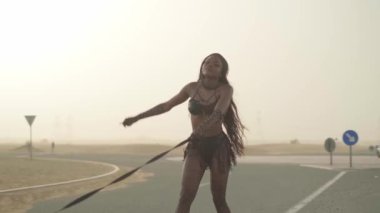 Seksi kıyafetli genç esmer kadın çölde yolda pahalı bir spor arabaya liderlik ediyor. Yavaş Hareket.