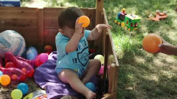 Een Kleine Jongen Zijn Moeder Spelen Met Kleurrijke Ballen Een — Stockvideo