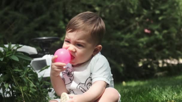 Маленький Хлопчик Шортах Сидить Траві Парку Грає Пластиковим Ячем Повільний — стокове відео