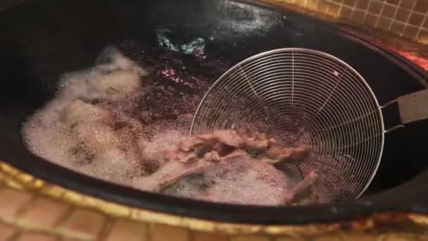 Szef Kuchni Wkłada Kawałki Mięsa Łyżeczką Oleju Gotującego Się Dużym — Wideo stockowe