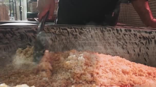 요리사는 스푼으로 필라프 콜드론에 저어줍니다 슬로우 — 비디오