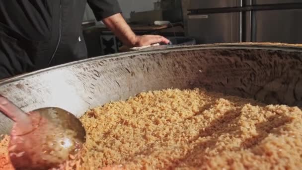 厨师用一个开槽的勺子在一个大的皮面包锅里搅拌米饭 慢动作 — 图库视频影像