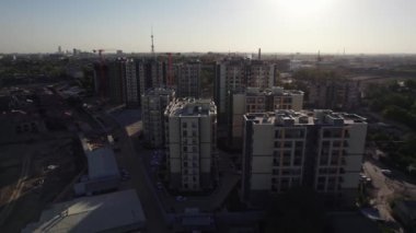 İnsansız hava aracı güneşli yaz gününde apartmanların üzerinden uçuyor.