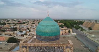Bir İHA, Poi-Kalon mimari kompleksinin üzerinde uçuyor. Özbekistan 'ın eski Buhara kentindeki bir evin arka planında. Bulutlu bir gün. Hava Görünümü.