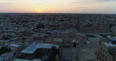 Özbekistan 'ın Buhara kentindeki eski evler arasında Poi-Kalon mimari kompleksinin üzerinde bir dron uçuyor. Erkenden bulutlu bir sabah. Hava Görünümü.