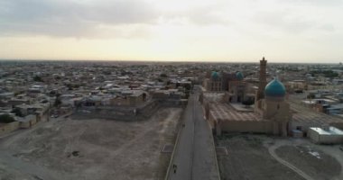 Özbekistan 'ın Buhara kentindeki eski evler arasında Poi-Kalon mimari kompleksinin üzerinde bir dron uçuyor. Erkenden bulutlu bir sabah. Hava Görünümü.