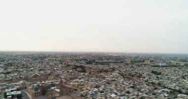 Özbekistan 'ın Buhara kentindeki eski evler arasında Poi-Kalon mimari kompleksinin üzerinde bir dron uçuyor. Erkenden bulutlu bir sabah. Hava Görünümü.