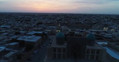 Özbekistan 'ın Buhara kentindeki eski evler arasında Poi-Kalon mimari kompleksinin üzerinde bir dron uçuyor. Erkenden bulutlu bir sabah. Hava Görünümü.