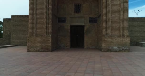 ドローンはウズベキスタンの古いブハラにあるマグック アッタリ モスク複合体のメインゲートの近くで飛ぶ 曇った日 エアリアルビュー — ストック動画