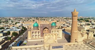 Güneşli ve bulutlu bir günde antik bir Kalyan Minaresi 'nin kulesinin üzerinde bir dron uçuyor. Eski Buhara, Özbekistan. Hava Görünümü.