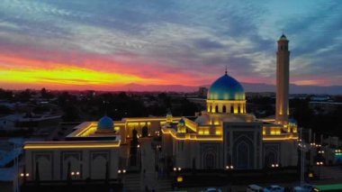 Bir İHA şehrin camisinin etrafında Sunrise 'ın arka planına doğru uçuyor. Bulutlu bir sabah. Hava Görünümü.