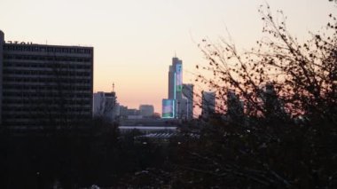 Kış şehrinin çatılarının üzerinde gün batımı. Kış