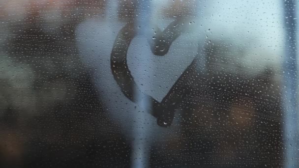 在冰柱和冬城的背景下 雾蒙蒙的窗户上有心形图案 — 图库视频影像