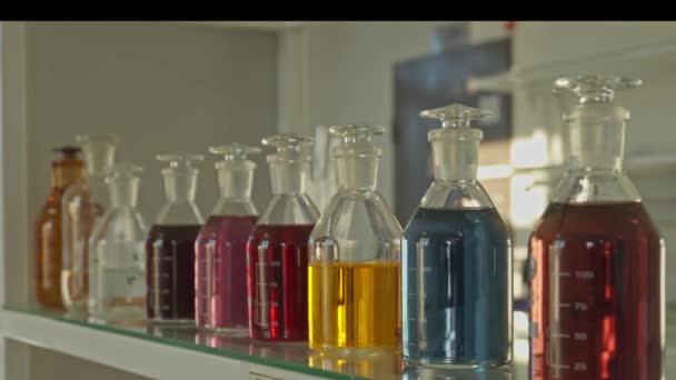 装有五彩缤纷化学品的玻璃瓶放在实验室的架子上 慢动作 — 图库视频影像