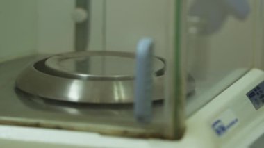Bir kimya laboratuvarında hassas bir denge üzerine tartılıyor. Yakın çekim, yavaş çekim