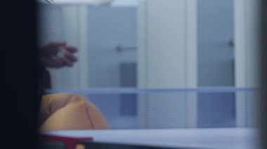 Ofis kıyafetleri içindeki insanlar masa tenisi oynuyor. Yakın çekim, yavaş çekim