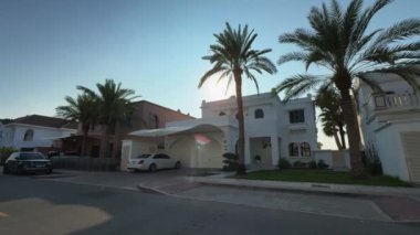 Bulutsuz bir günde Dubai 'de, deniz kenarında palmiye ağaçlarının arasında pahalı bir villanın dışında. Yavaş Hareket.
