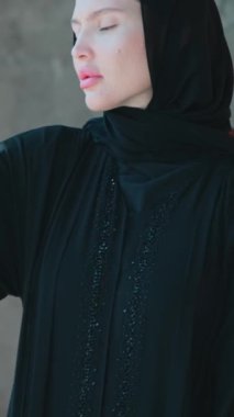 Abaya 'nın Arap milli elbisesi içinde genç bir kadın. Elbisenin yakın çekimi. Yavaş Hareket.