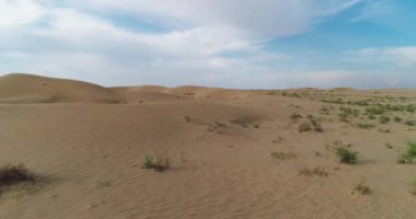 İnsansız hava aracı bulutlu bir günde çölün kum tepelerinin üzerinden uçar. Hava görünümü