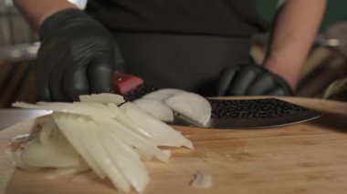 Şef soğanı kesme tahtasına bıçakla kesiyor. Yavaş Hareket.